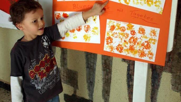 Timo Beierlorzer (4) zeigt sein Bild zum Thema Blumenwiese, das er mit Tagetesdruck im Kindergarten gefertigt hat.