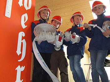 Sie sind schon mal in die Feuerwehruniform geschlüpft und haben zum Schlauch gegriffen. Bei der Mini-Feuerwehr in Langenleiten wird das Löschen quasi vom Kindergartenalter an geübt.  Foto: Marion Eckert