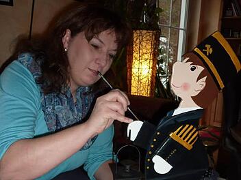 Mit sicherem Strich bemalt Sandra Brauer kleine Knappen im schmucken Bergmannskleid, die mittlerweile heiß begehrt sind. Foto: Gerd Fleischmann