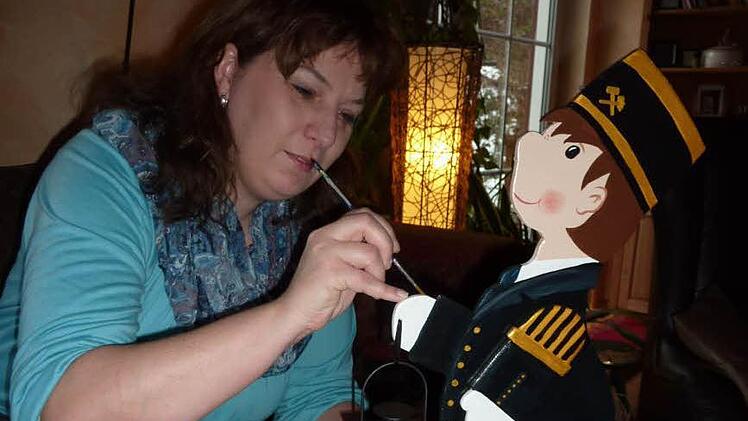 Mit sicherem Strich bemalt Sandra Brauer kleine Knappen im schmucken Bergmannskleid, die mittlerweile heiß begehrt sind. Foto: Gerd Fleischmann