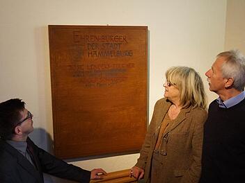 Bürgermeister Armin Warmuth, José Lenders und Ernst Stross (von links) betrachten die neue Ehrenbürger-Tafel. Foto: Arkadius Guzy