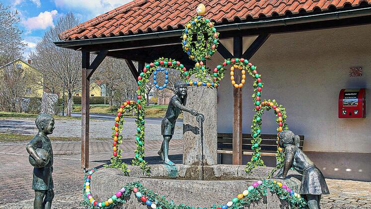 Ein bunt geschmückter Osterbrunnen ziert den Platz vor dem alten Schul- und Rathaus in Kleinwenkheim. Auf dem dazugehörigen Parkplatz soll das Car-Sharing-Auto stationiert werden, wenn sich genügend Bürger für dieses Experiment finden. Foto: Dieter Britz