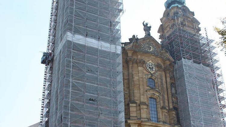 Die nach der Restaurierung wieder golden glänzenden Turmspitzen schauen schon seit geraumer Zeit oben aus der Verhüllung heraus. Foto: Popp