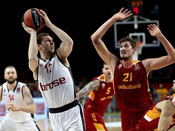 Janis Strelnieks (l.) schließt unter dem Korb ab, Tibor Pleiß im Trikot von Galatasaray kommt zu spät. Foto: dpa