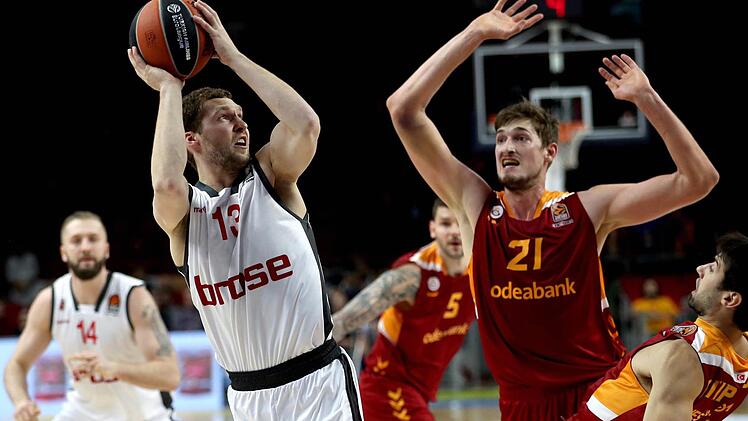Janis Strelnieks (l.) schließt unter dem Korb ab, Tibor Pleiß im Trikot von Galatasaray kommt zu spät. Foto: dpa
