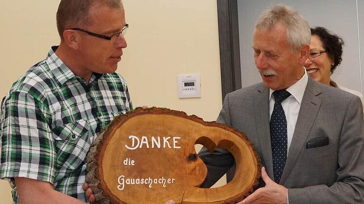 Edmund Schaupp schenkt im Namen der Gauaschacher ein Stück der Dorflinde