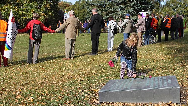 Ein junges Mädchen legt Rosen auf den russischen Friedhof.