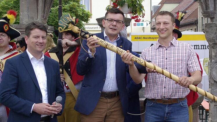 Bürgermeister Armin Warmuth (M.) reichte den Rhöner Wanderstab an seinen Amtskollegen Martin Müller (rechts) weiter, der damit 2017 den achten Rhöner Wandertag in Vacha eröffnet. MdL Sandro Kirchner beobachtet die Übergabe. Foto: Winfried Ehling