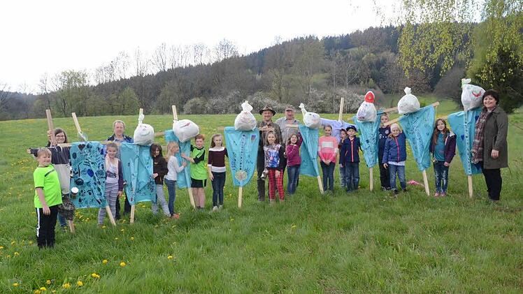 Auf einer Wiese bei Neukenroth überreichten die Schüler der GS Stockheim ihre selbst gebastelten und bemalten Wildscheuchen an den Landwirt Gottfried Weißerth (Mitte, r.), der diese aufstellen wollte, um Rehkitze vor dem Mähtod zu schützen - mit im Bild, hinten von links Jessica Proksch, Siegbert Jakob und Bernhard Schmitt sowie Schulleiterin Astrid Kestel (r.). Foto: eh