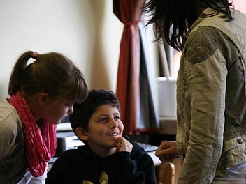 Muhanad Eiz Eddin mit Banknachbarin Elena Hoffmann und Lehrerin Stephanie Leutheußer im Mathematikunterricht. Foto: Matthias Beetz
