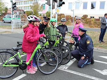 Die Kinder freuen sich genauso über die neuen Fahrräder, wie die Polizisten, die sie darauf unterweisen. Fotos: Karina Brock