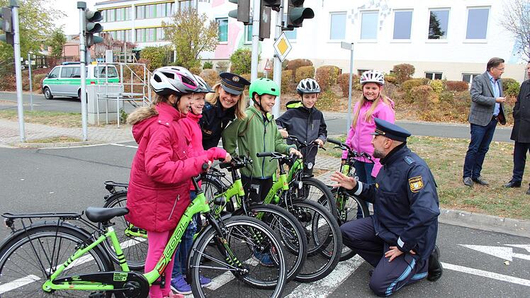 Die Kinder freuen sich genauso über die neuen Fahrräder, wie die Polizisten, die sie darauf unterweisen. Fotos: Karina Brock