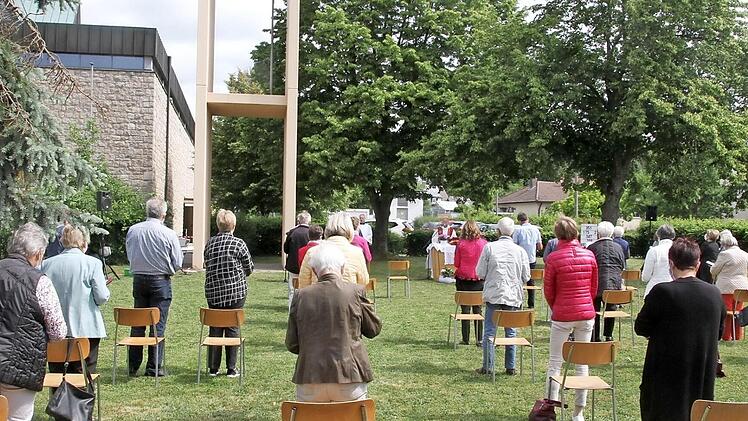 Voll besetzte Stühle auf der Wiese neben dem Glockenturm bei der feierlichen Wiederaufnahme des Gottesdienstes in der Pfarrei St. Paul.