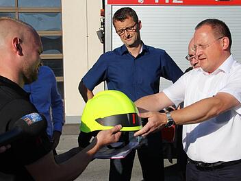 Die Feuerwehren Neu- und Neershof und Lützelbuch melden sich ab mit symbolischer Helmübergabe. Von links: Stadtbrandinspektor Daniel Fritz, Ordnungsamtsleiter Kai Holland, der in diesem Moment schon ehemalige Kommandant der Feuerwehr Lützelbuch, Stefan Büttner. Foto: sb