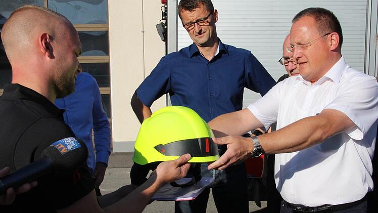 Die Feuerwehren Neu- und Neershof und Lützelbuch melden sich ab mit symbolischer Helmübergabe. Von links: Stadtbrandinspektor Daniel Fritz, Ordnungsamtsleiter Kai Holland, der in diesem Moment schon ehemalige Kommandant der Feuerwehr Lützelbuch, Stefan Büttner. Foto: sb