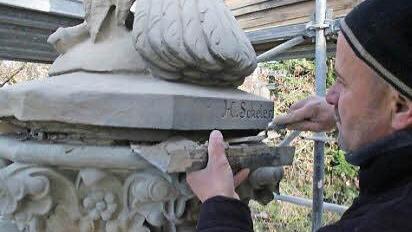 Steinmetzmeister Christoph Klesse bringt Mörtel zwischen Sockel und Adler. Das neogotische Sockelkapitell hat Klesse komplett neu gefertigt.