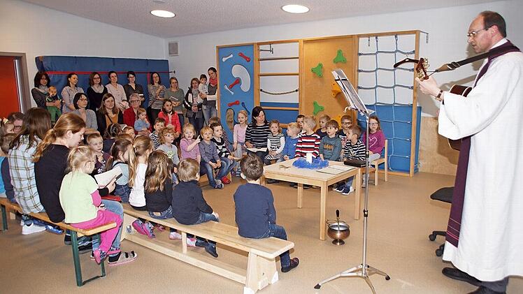Mit einem kleinen Segensgottesdienst nahmen Pfarrer Kurt Wolf und die Kinder das generalsanierte Kindergartengebäude in Untersteinbach wieder in Betrieb.  Foto: Sabine Weinbeer