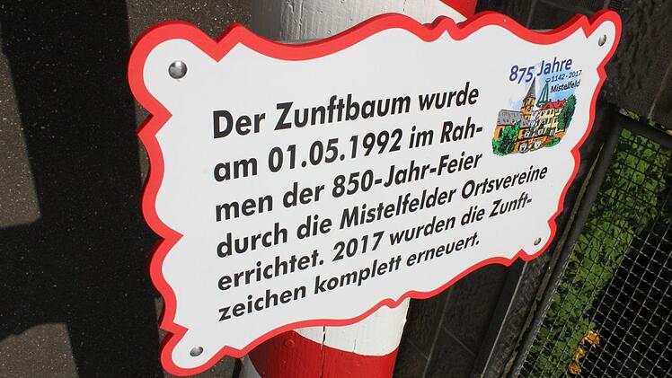Ein bisschen Ortsgeschichte gibt es für den Betrachter des nunmehr etwa 18 Meter hohen Mistelfelder Zunftbaumes dazu. Oberhalb dieses Textes reihen sich die 18 Zunftschilder plus zwei Schilder mit den Wappen Frankens und der Stadt Lichtenfels. Foto: Popp