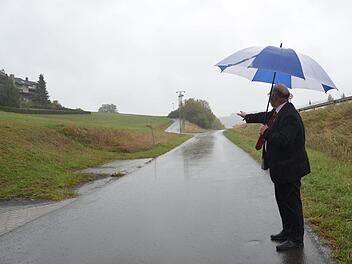 Letztlich wurde Bürgermeister Egon Herrmann nicht im Regen stehen gelassen wie es das Bild am Baugebiet Sachspfeife ausdrücken könnte. Hinter der Straße im Hintergrund soll das Baugebiet entstehen, für das noch eine Studie zur Feuersicherheit abgewartet werden muss. K.-H. Hofmann