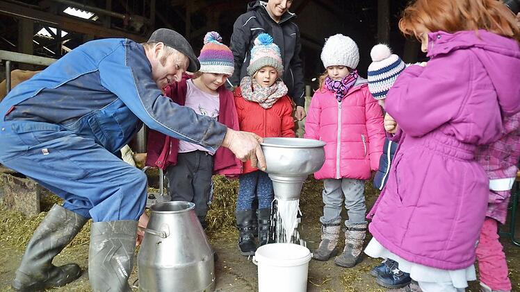 Senior Karl Schneider, der auf dem Hof hin und wieder aushilft, zeigt hier den Kindern, wie die Milch nach dem Melken gefiltert wird. Staunend verfolgen Pauline (von links), Charlotte, Ida, Anne, Franzi und Paola, wie die Flüssigkeit durch das Sieb läuft. Hinter der Gruppe steht Verena Schneider.