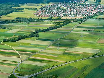 Die Kreisstraße (von unten nach oben)  zwischen Hallstadt und Gundelsheim (oben im Bild) wird 2018 ertüchtigt, einen neuen Radweg entlang der Straße gibt es  dabei  aber nicht. Für Radler  wird der Feldweg (links) ausgebaut.Luftbild:   Ronald Rinklef