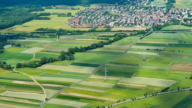 Die Kreisstraße (von unten nach oben)  zwischen Hallstadt und Gundelsheim (oben im Bild) wird 2018 ertüchtigt, einen neuen Radweg entlang der Straße gibt es  dabei  aber nicht. Für Radler  wird der Feldweg (links) ausgebaut.Luftbild:   Ronald Rinklef