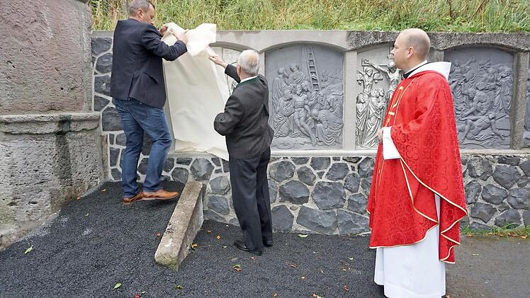 Die Enthüllung der neuen Kreuzwegstationen durch Klaus und Günter Metz.  Foto: Eckert