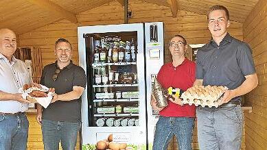 Direktvermarkter Udo Bohl, Imker Matthias Reg und Landwirt Patrick S&auml;mann (von links) bef&uuml;llen den Automaten. B&uuml;rgermeister Martin Finzel (Zweiter von links) findet das toll.