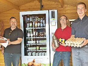 Direktvermarkter Udo Bohl, Imker Matthias Reg und Landwirt Patrick Sämann (von links) befüllen den Automaten. Bürgermeister Martin Finzel (Zweiter von links) findet das toll.