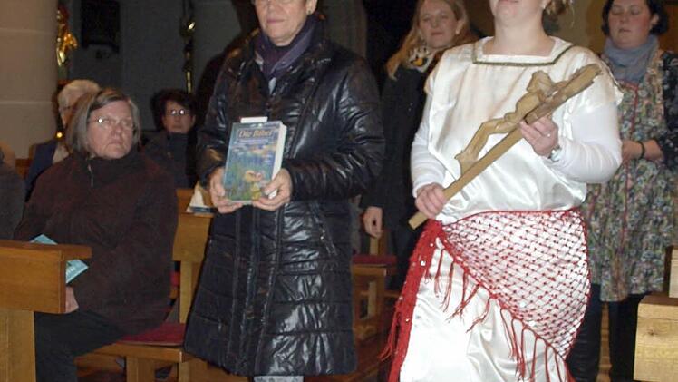 Beim Einzug bringen die Frauen des Vorbereitungsteam die Bibel (Claudia Völk, li) und das Kreuz (Gisela Schmermer, re.) zum Altar. Foto: Susanne Deuerling