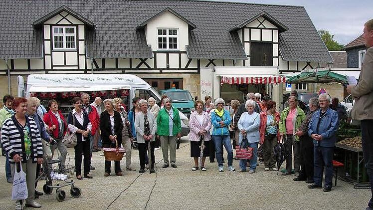 Vor den ehemaligen Domänengebäuden informiert Bürgermeister Michael Keilich (rechts) die zur Eröffnung gekommenen Marktbesucher über das vor Jahrhunderten begründete Sonnefelder Marktrecht. Foto: Klaus Oelzner