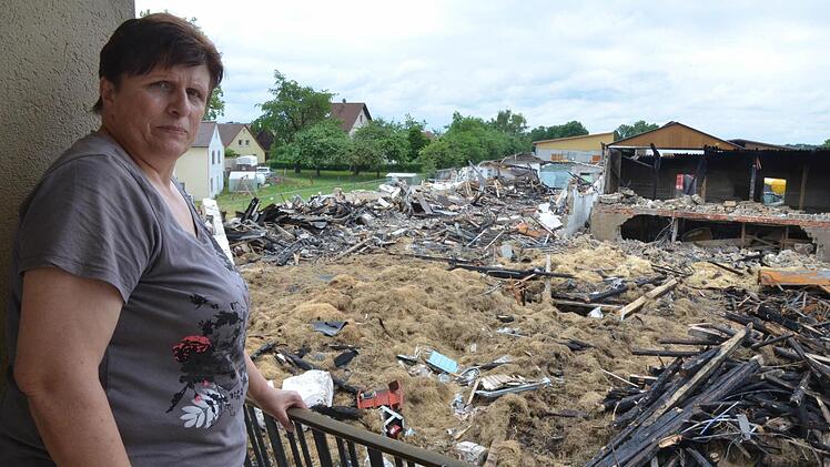 Vom Balkon des Wohnhauses hat Irmgard Schmidt vor Augen, was das Feuer von ihrem Hof übrig gelassen hat. Foto: Rainer Lutz