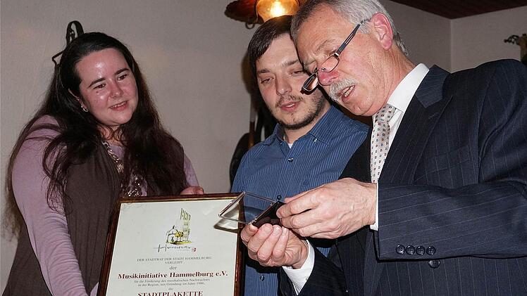 Nicole Oppelt und Daniel Wolf (von links) nahmen die Stadtplakette für die Musikini von Ernst Stross entgegen.