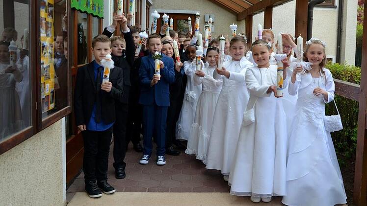 Stolz zeigten die Strullendorfer Erstkommunionkinder ihre selbst gestalteten Kerzen, die sie für ihre Erstkommunion-Feier angefertigt haben. Foto: Andrea Spörlein