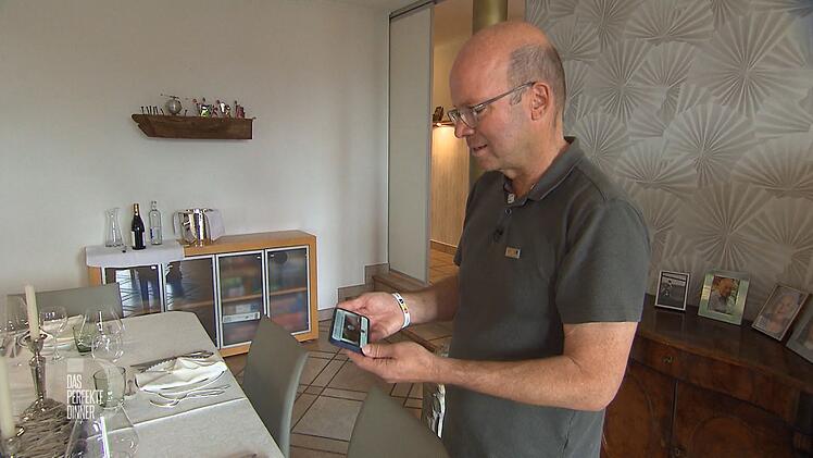 Volker erhält von Carola eine Videobotschaft: Sie ist leider zu krank, um heute am "Dinner" teilzunehmen.