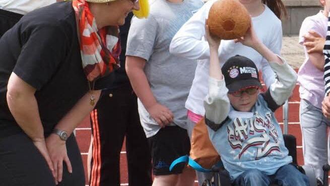 Auch ein Rollstuhl ist kein Hindernis, um Sport zu treiben, wie dieser Junge beim Medizinballwerfen beweist.