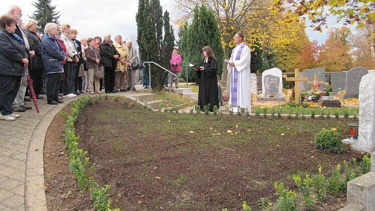 Die evangelische Pfarrerin Anja Bautz und der katholische Pfarrer Georg Birkel segneten die neu gestaltete Grabstätte auf dem Staffelsteiner Friedhof. Das Gräberfeld hat etwa die Form eines Dreiecks und ist von Buchsbaum umsäumt. Foto: Monika Schütz