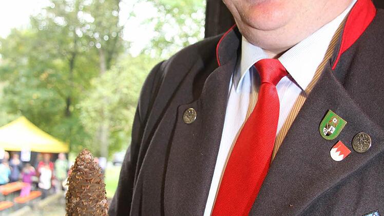 Landrat Klaus Peter Söllner mit einem Tannenzapfen.