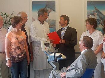 Das Onkologische Zentrum am Klinikum Coburg verfügt dank einer Spende der Sparkasse Coburg Lichtenfels nun über ein innovatives Bewegungs-Trainingsgerät, das zur Therapie und Prophylaxe eingesetzt wird (von links): Hermann Filsner, Irmtraud Kaiser, Dr. med. Diethard Eichmann, Dr. med. Christof Lamberti, Siegfried Wölki, Ulla Blum und Tanja Eller, auf dem Trainer sitzend Hans Morhard.  Foto: Gabi Arnold