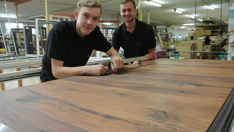 Am 1. September ist offiziell Ausbildungsbeginn. Die Lehrlinge (von links) Daniel Baum und Johannes Mück arbeiten allerdings schon etwas länger bei der Krines GmbH in Sand. Hier fertigt man beispielsweise solche Sicherheitseingangstüren. Diese hier ist mit edlem Furnier aus uraltem Eichenholz überzogen.