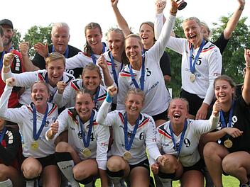 Das Team von Bundestrainerin Silke Eber (rechts hinten, verdeckt) feiert den EM-Hattrick. Foto: DFBL/Spille