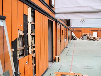 Um auszuschließen, dass hinter Verkleidungen und unter Bodenbelägen möglicherweise Schadstoffe lauern, wurden an vielen Stellen in der Dreifachsporthalle Proben genommen, wie hier in der großen Halle an den markanten orangefarbenen Paneelen. Ulrike Nauer