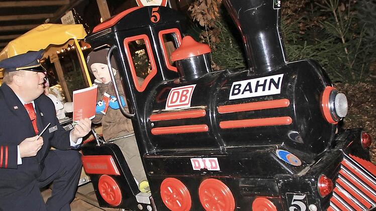 Peter Dauth schickt die erste Bahn auf die Strecke. Zuvor beschenkt er die Kinder noch mit Süßigkeiten und Malbüchern. Fotos: Matthias Einwag