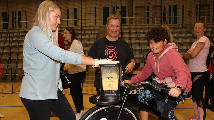 Trete auf den Adidas Smoothie Bike in die Pedale und mixe Dir Deinen eigenen Smoothie! Von links: Anna Khudzik, Jeannette Domke und auf dem Rad Ana Foto: Desombre