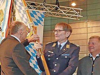 Aus der Hand von Oberst a.D. Richard Drexl (Mitte) erhält Generalmajor a.D. Norbert Wagner (links) die Standarte des BSB, Staatsminister Christian Bernreiter (rechts) gratuliert.