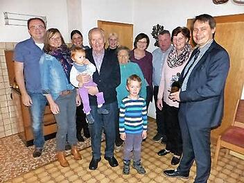 Jubilar Otmar Bähr (vorne) mit Enkelin Helena auf dem Arm sowie Enkel Jeremia (rechts daneben) und Bürgermeister Roland Wolfrum (rechts) im Kreise der Familie und Nachbarn Foto: Klaus-Peter Wulf