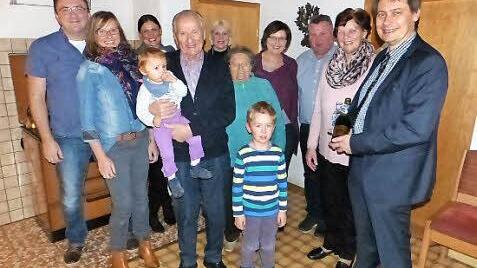 Jubilar Otmar Bähr (vorne) mit Enkelin Helena auf dem Arm sowie Enkel Jeremia (rechts daneben) und Bürgermeister Roland Wolfrum (rechts) im Kreise der Familie und Nachbarn Foto: Klaus-Peter Wulf