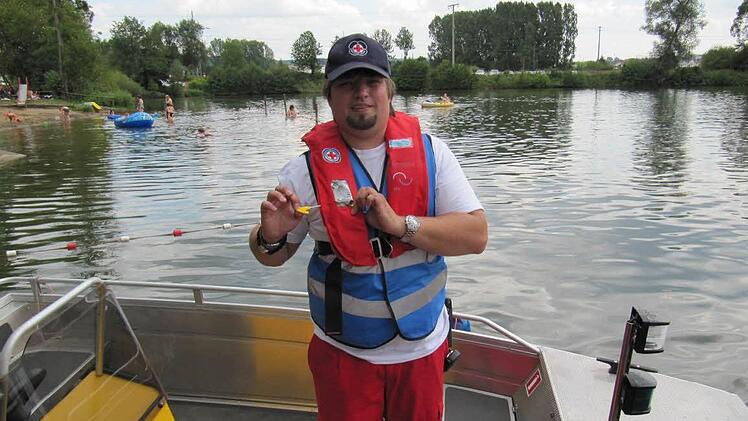 Wachleiter Florian Gehringer: mit einem Ruck am gelben Plastikteil wird die Rettungsweste manuell ausgelöst und bläst sich in Sekundenschnelle auf.