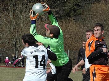 Gekonnt pflückt sich Aschachs Keeper Andre Dippacher das Leder. Wildfleckens Uli Weikard und Teamkollege Sebastian Tröster (rechts) gehen in Deckung. Foto: Sebastian Schmitt