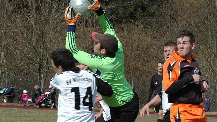Gekonnt pflückt sich Aschachs Keeper Andre Dippacher das Leder. Wildfleckens Uli Weikard und Teamkollege Sebastian Tröster (rechts) gehen in Deckung. Foto: Sebastian Schmitt